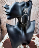 Outlaw Square Hoop Fashion Earrings on a mannequin, sitting on cowhide, wood back drop.
