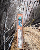 Far & Wide Hand-Tooled Key Fob displayed on wheat, wood back drop.