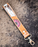 Far & Wide Hand-Tooled Key Fob displayed on cow hide.