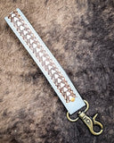 Diamond Shine Hand-Tooled Strap Key Fob displayed on cow hide.
