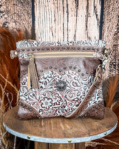 Front view of the Azure Aesthetic Leather & Hairon Bag on a wood table, wood backdrop.
