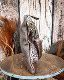 Side view of the Azure Aesthetic Leather & Hairon Bag on a wood table, wood backdrop.