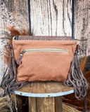 Back view of the Sandy Rosewood Hand-Tooled Bag displayed on a wood table, wood back drop.