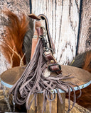 Side view of the Sandy Rosewood Hand-Tooled Bag displayed on a wood table, wood back drop.