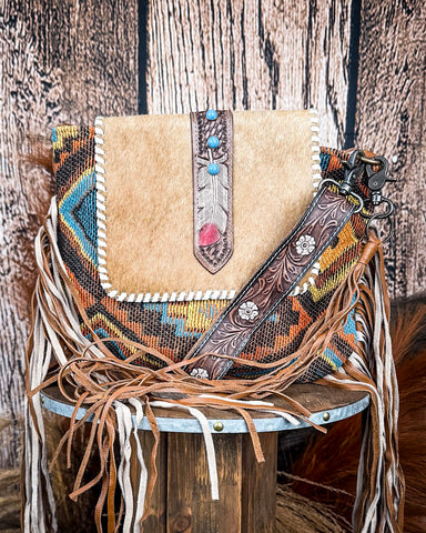 Front view of the Beaded Frills Hand-Tooled Bag displayed on a wood table, wood back drop.