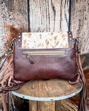Back view of the Carved Blossoms Leather & Hairon Bag displayed on a table, wood back drop.