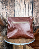 Back view of the Fennington Leather Bag in Ivory displayed on a wood table, wood back drop.