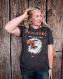 Girl modeling the Badlands Motorcycle Club Graphic Tee with a wood back drop.
