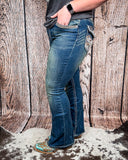 Side view of a girl modeling the Emberglow Embellished Bootcut Jeans, standing on cowhide.