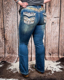 Back view of a girl modeling the Emberglow Embellished Bootcut Jeans, standing on cowhide.