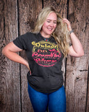 Model wearing the Raised on 90's Country Distressed Graphic Tee with a wood back drop.