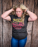 Model wearing the Raised on 90's Country Distressed Graphic Tee with a wood back drop.