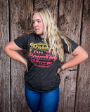 Model wearing the Raised on 90's Country Distressed Graphic Tee with a wood back drop.
