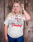 A girl modeling the Kick Rocks Cowboy Distressed Graphic Tee with a wood backdrop.