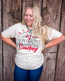 A girl modeling the Kick Rocks Cowboy Distressed Graphic Tee with a wood backdrop.