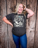 Model wearing the Cowboys Never Die Distressed Graphic Tee with a white back drop.