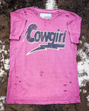 The Lightning Cowgirl Distressed Graphic Tee displayed on cowhide.