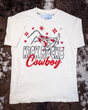 The Kick Rocks Cowboy Distressed Graphic Tee displayed on cowhide.