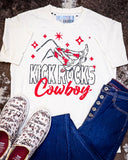The Kick Rocks Cowboy Distressed Graphic Tee displayed on cowhide along with shoes and jeans.
