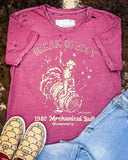 The Urban Cowboy Distressed Graphic Tee displayed on cowhide along with shoes and jeans. 