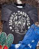 Honky Tonk Gal Vintage Graphic Tee displayed on cowhide along with shoes and jeans,