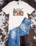 Front view of the The Laredo Longhorn Graphic Tee displayed on cowhide along with jeans.