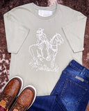 The Legacy Rider Graphic Tee displayed on cowhide along with shoes and jeans,