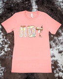 The Blooming Cowgirl Essentials Graphic Tee displayed on cowhide.