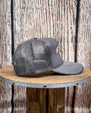 Side view of the Embroidered Rope Howdy Trucker Cap displayed on a wood table, wood backdrop.
