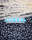 The Rayna Genuine Turquoise Bracelet displayed on beans and wheat.