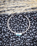 Top view of the Abha Genuine Turquoise Bracelet displayed on beans and wheat.