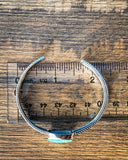 Top view of the Abha Genuine Turquoise Bracelet displayed on a table.