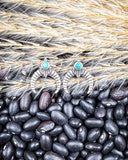 The Naja Genuine Turquoise Earrings displayed on beans and wheat.