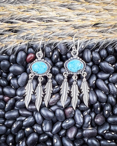 The Abey Genuine Turquoise Fringe Earrings displayed on beans and wheat.