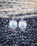 The Abeytu Genuine Turquoise Earrings displayed on beans and wheat.