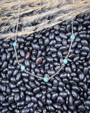 The 5 Stone Genuine Turquoise Choker Necklace displayed on beans and wheat.