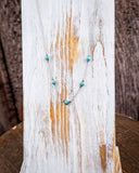 The 5 Stone Genuine Turquoise Choker Necklace displayed on a wooden plank.