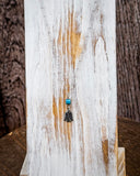 The Thunderbird Charm Genuine Turquoise Necklace displayed on a wooden plank, wood backdrop.