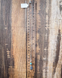 The Thunderbird Charm Genuine Turquoise Necklace displayed on a ruler showing size, wood backdrop.