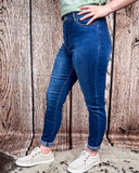 Side view of the Midnight Range Skinny Jeans worn by a girl that is standing on cowhide.