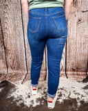 Back view of the Midnight Range Skinny Jeans worn by a girl that is standing on cowhide.