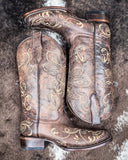 Dustwing Canyon Circle G Boots laying on cowhide.