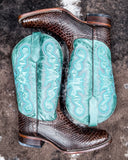 Serpent Spur Circle G Boots laying on cowhide.