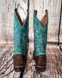 Back view of the Serpent Spur Circle G Boots in front of a wood backdrop.
