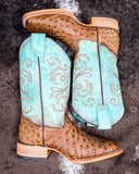 Stormbird Ostrich Corral Boots laying on cowhide.