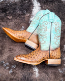 Stormbird Ostrich Corral Boots laying on cowhide.