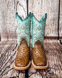 Front view of the Stormbird Ostrich Corral Boots in front of a wood backdrop.