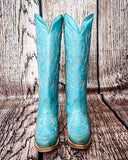 Front view of the Embroidered Sky Corral Boots with a wood backdrop.