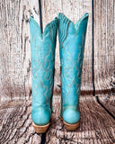 Back view of the Embroidered Sky Corral Boots with a wood backdrop.