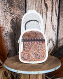 Front view of the Ridge Bloom Tooled Sling Bag - Ivory on a wood backdrop.